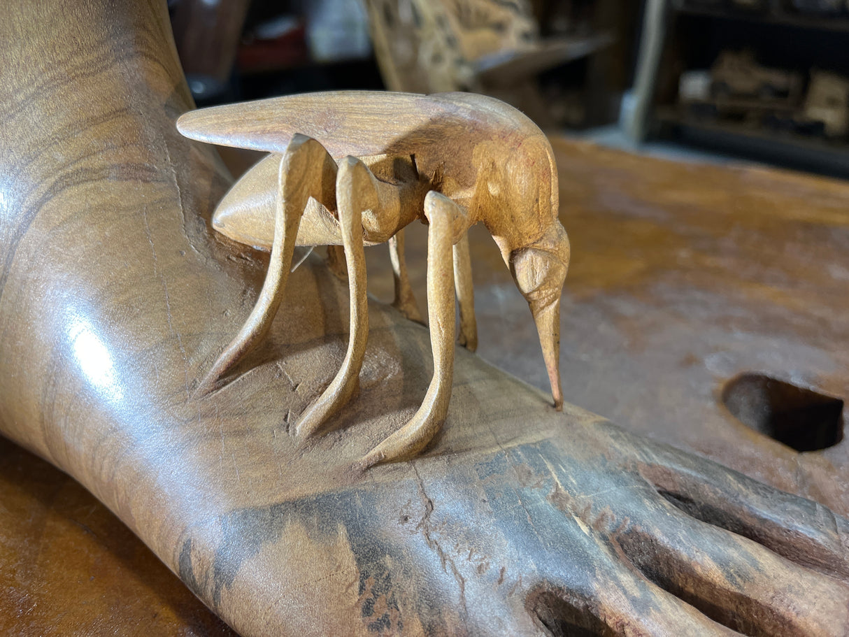 Carved Sculpture of a Mosquito Biting on a Foot